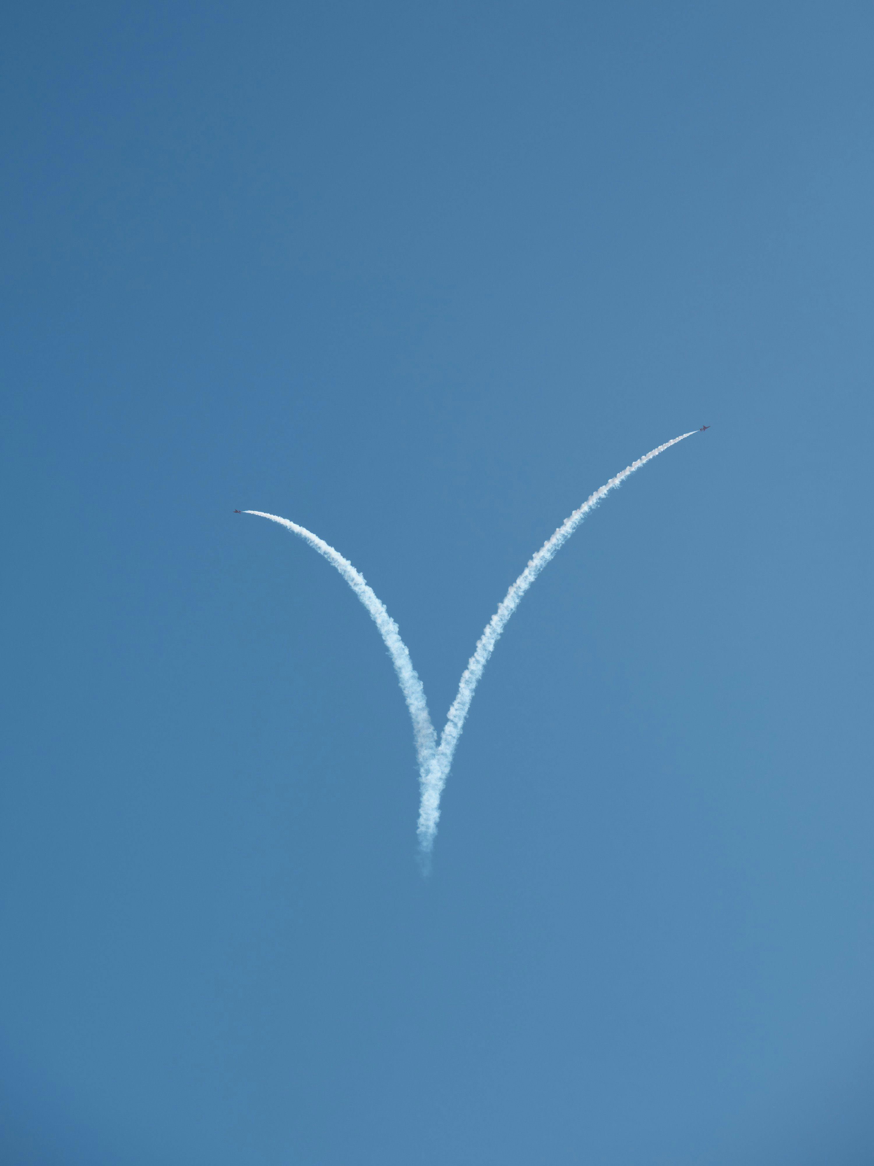 The Red Arrows in the process of forming a heart out of their smoke trailers, it currently forms a "V"