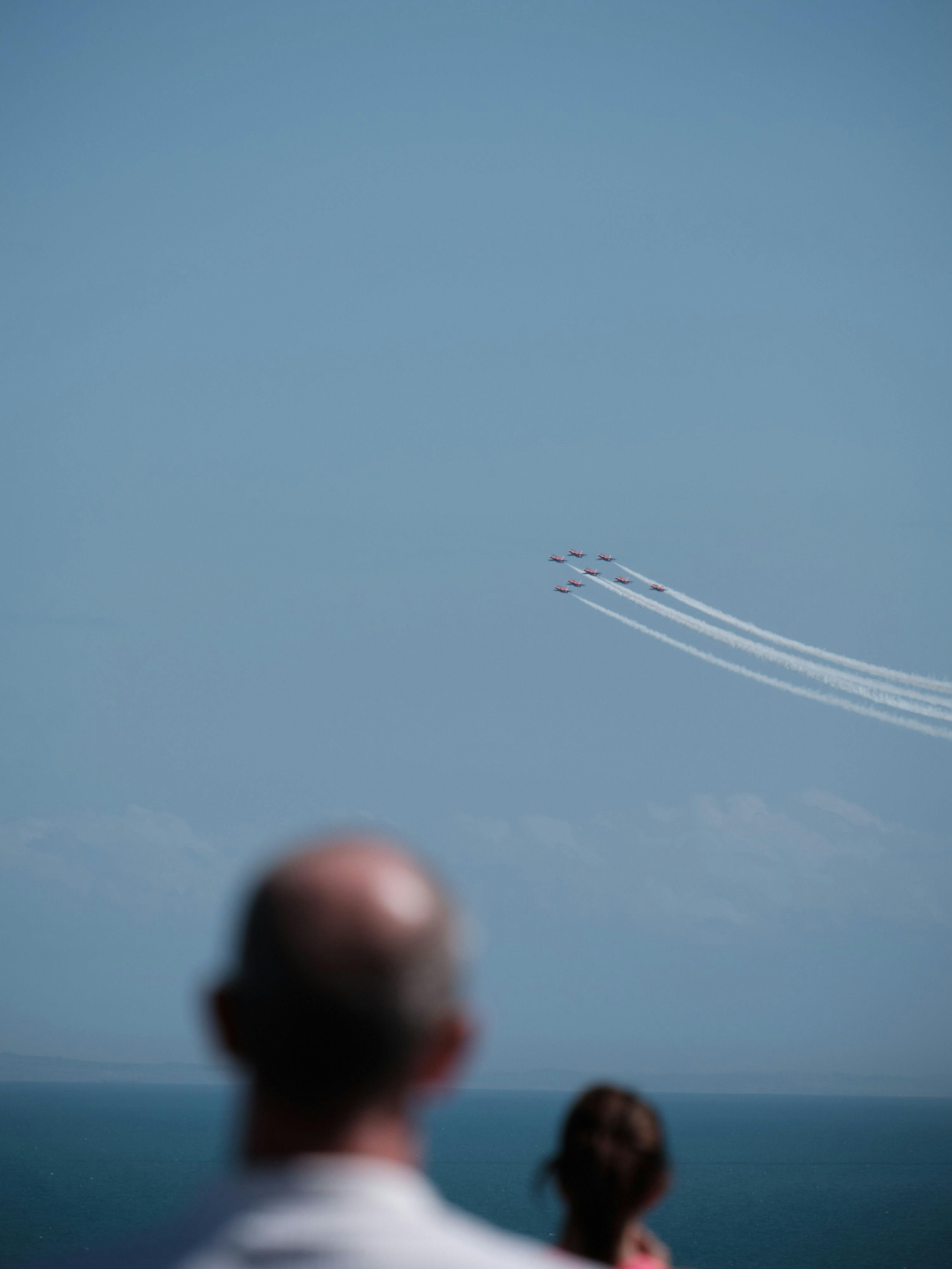 The Red Arrows fly across The Channel, people look on out of focus